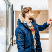 Man adjusting temperature with thermostat at home
