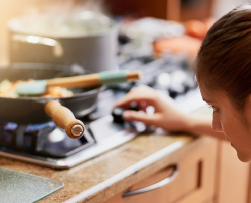 Cooking, kitchen and woman light gas stove in home for healthy diet, nutrition and meal preparation for eating food. Chef, pan and girl at cooker for lunch, dinner and turn on appliance in house