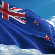 New Zealand flag waving against a blue sky