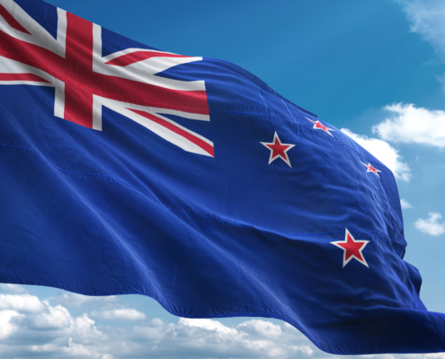 New Zealand flag waving against a blue sky