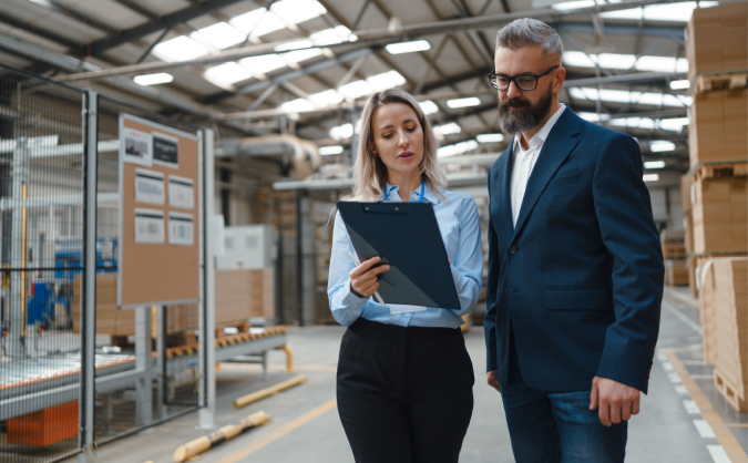 two warehouse workers examine a manifest